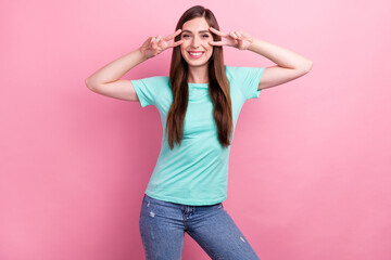 Photo of adorable charming young woman dressed turquoise t-shirt showing v-sign cover eyes smiling isolated pink color background