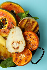 Concept of tasty food with grilled fruits on blue background