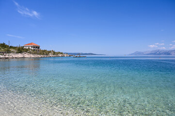 Fototapeta premium Sea and beach at summer. Soft sea waves on beautiful sandy beach. Vacation, travel and tourism concept. 