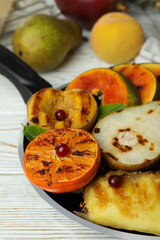 Concept of tasty food with grilled fruits on white wooden table