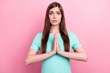 Photo of dreamy upset young woman dressed turquoise t-shirt arms together asking forgiveness...