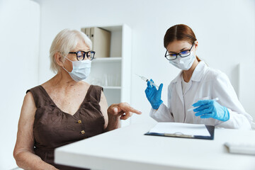 elderly woman wearing a medical mask in the hospital for vaccinations immunity protection