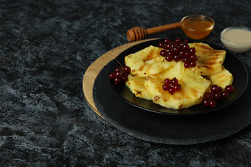 Concept of tasty food with grilled pineapple on black smokey background