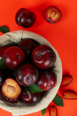 Decorative bowl with plums on an orange background
