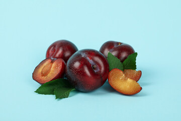 Plums with leaves on a blue background