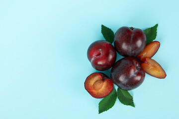 Plums with leaves on a blue background