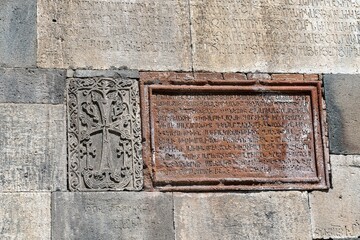 Armenia, Geghard, September 2021. Religious symbols and texts in Armenian on the wall of an ancient temple.