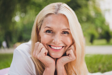 Fototapeta premium Photo of mature sweet blond lady wear white t-shirt in park alone