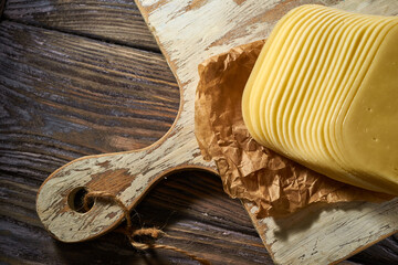 Sliced pieces of cheese on rustic wooden background, cheese sandwiches