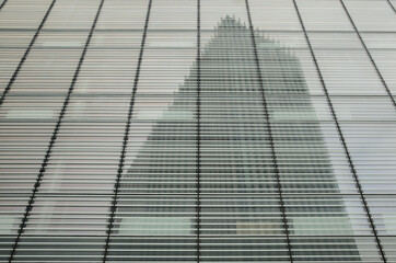 Skyscraper in steel and glass reflected on the glass of another skyscraper