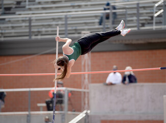 High School girls competing in pole vault at a track and field meet