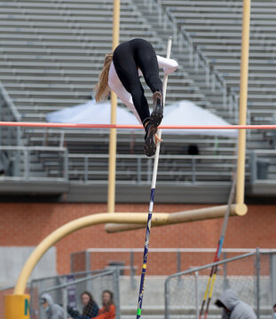 High School girls competing in pole vault at a track and field meet