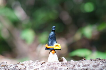 A figure of a dwarf made of plasticine in a festive hat. The concept of Halloween.