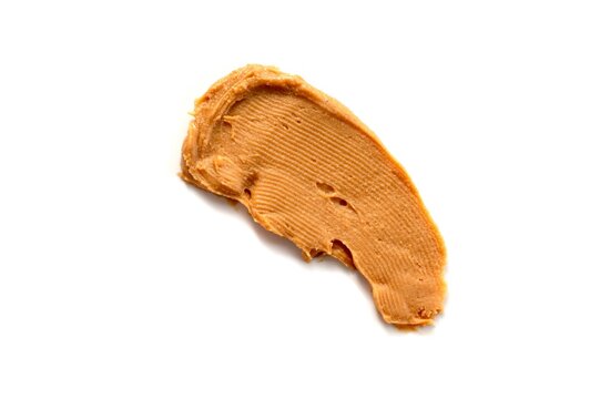 Peanut butter spread isolated on white background, top view