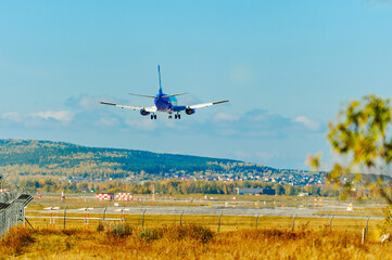 The plane lands at the Koltsovo international airport in Yekaterinburg against the backdrop of the Ural Mountains. Travel across the Urals. Vacation flights.