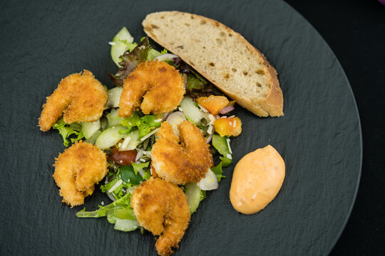 Mit Panko panierte und frittierte Black Tiger Garnelen mit Salat und Speckbrot