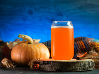 A glass of craft autumn beer, blue backlit background. Autumn composition on the table