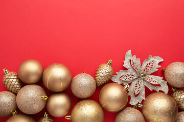 Gold Christmas toys decoration on red background with copy space. New Year greeting card. Minimal style. Flat lay.