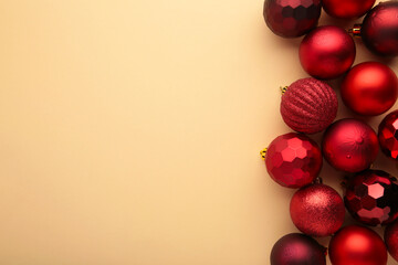 Red Christmas baubles decoration on beige background with copy space. New Year greeting card. Minimal style. Flat lay.
