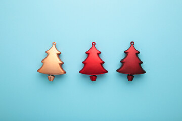 Gold and red christmas plastic fir tree on blue background. Minimalism. Flat lay