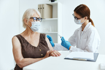 female doctor makes an injection in the arm immunity protection covid passport