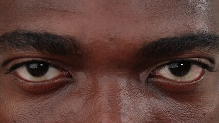 Close up of a black man face opening his eyes. Macro.