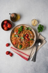 Whole wheat pasta with tomato sauce, fresh tomatoes and basil. Top view, empty space