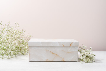Cosmetic presentation podium made of paper marble gift box . Product display with white flowers in...