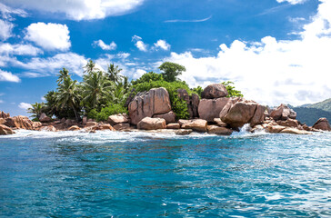 Beautiful island of Seychelles, granite cliffs of the beach with palm trees and azure water. Vacation concept travel holiday banner background. Hawaiian Islands Paradise Beach. Luxury travel.