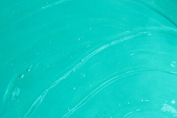 Jelly waved serum with bubbles on the blue background.Cosmetics smear of aloe vera or antibacterial...
