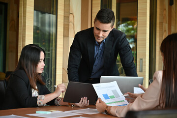 Photo of businesspeople working together at the wooden meeting desk. Collaboration of diversity concept
