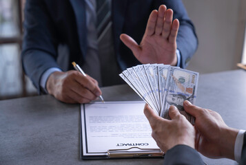 Businessman refusing money that comes with agreement paper, Anti bribery, and Anti Corruption...