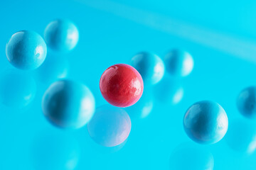 Blue and red balls flowing upwards on blue background. .One against all, concept photo. Concept of...