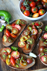 Croutons with cherry tomatoes, garlic and hot peppers. Healthy bruschetta with tomatoes.