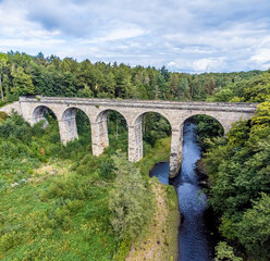 Fototapeta na wymiar A view along the River Nidd towards the Nidd Gorge Viaduct near to Knaresborough in Yorkshire, UK in summertime