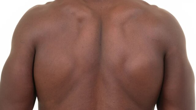 Closeup back view of a black man stretching his back. Isolated on white background.