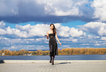 Full-length portrait of a young beautiful girl in a gray coat