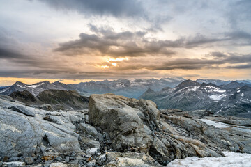 Rocky alpine mountains morning panorama. Cloudy sunrise on summer day. Grossglockner Mountain, Hohe Tauern National Park, Austrian Alps