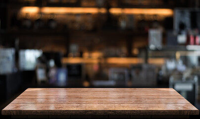 Empty wooden table top with lights bokeh on blur restaurant background.