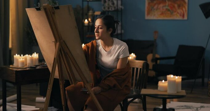 A young talented girl spends evenings pursuing passion, hobby, a woman draws beautiful sketches, paintings, portraits, extra income, long hours devoted to work, pencil strokes on the canvas