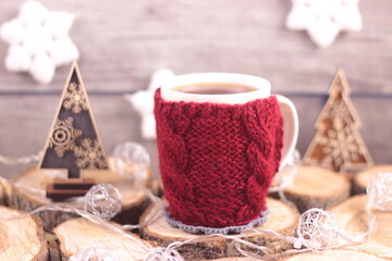 christmas mulled wine. cup of tea wrapped in knitted woolen case.