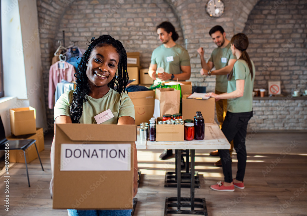 Wall mural portrait of african american female volunteer holding a box with donation.