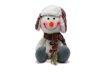 Funny snowman in a winter knitted hat and scarf with a carrot nose. Cute stuffed animal. New year gift. Christmas attribute. Christmas collection. Snowman.