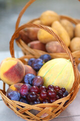 Two baskets full of fresh fruit and vegetable in a garden. Selective focus.