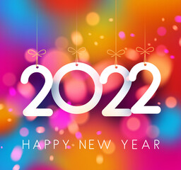 Hanging white 2022 sign on colorful bokeh background.