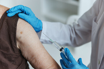 doctor with a syringe makes an injection in the arm vaccine passport close-up