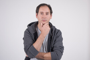 Portrait of a man with a pensive expression. He is dressed in casual gray clothes. 
He has striking brown eyes and white skin.
Our model has sparse hair.