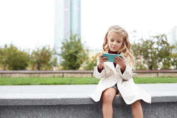 Funny child with long hair holding a mobile