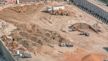 Wheel loader machine unloading sand at eathmoving works in construction site timelapse