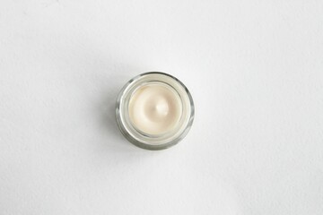 A jar of cosmetic greasy white face cream on a white background. Top view. Beauty and perfumes.